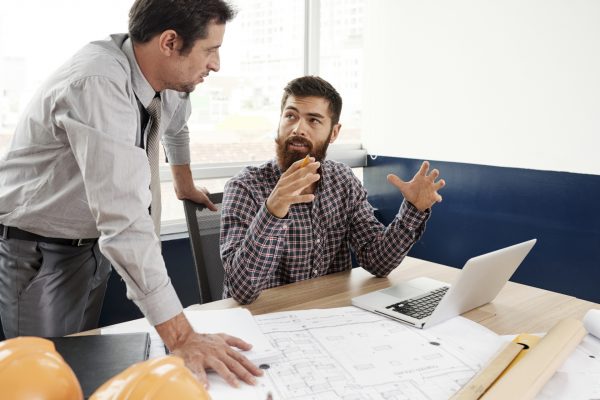 Team of architects discussing project of house at daily meeting