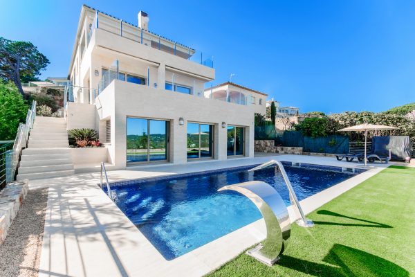Luxury modern house with swimming pool with waterfall jet. House marble